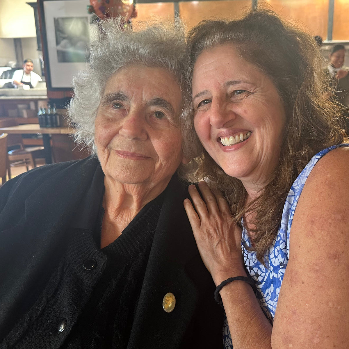 MaryAnn and her mother posing for a photo in a restaurant setting