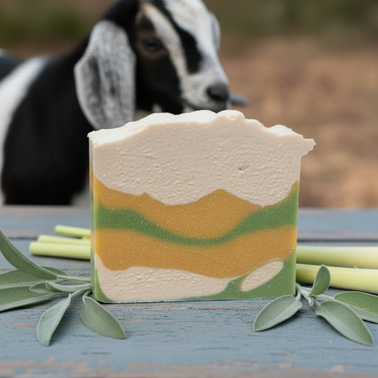Sage & Lemon Grass Goat milk soap bar with cream yellow and green camo coloring and cute nubian goat in the background.  